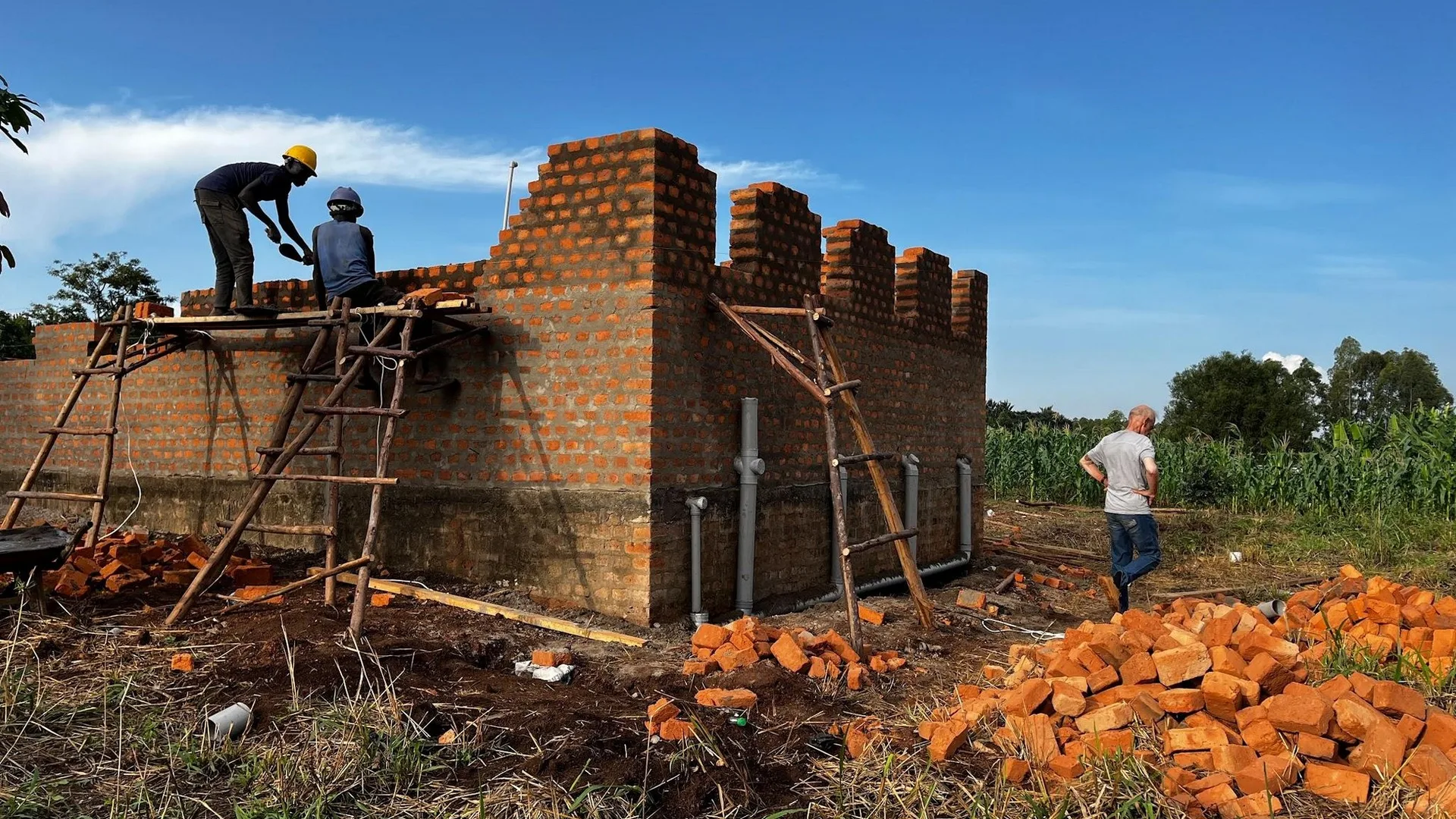Builders laying brick on the walls of the new training centre at Bweyale Vocational Education